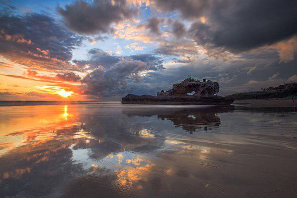 夕陽下海灘小船唯美風景圖片