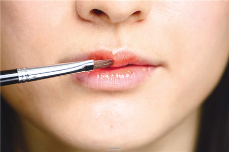 運用唇膏與工具搭配橘紅勾勒性感雙唇