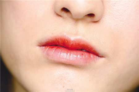 運用唇膏與工具搭配橘紅勾勒性感雙唇